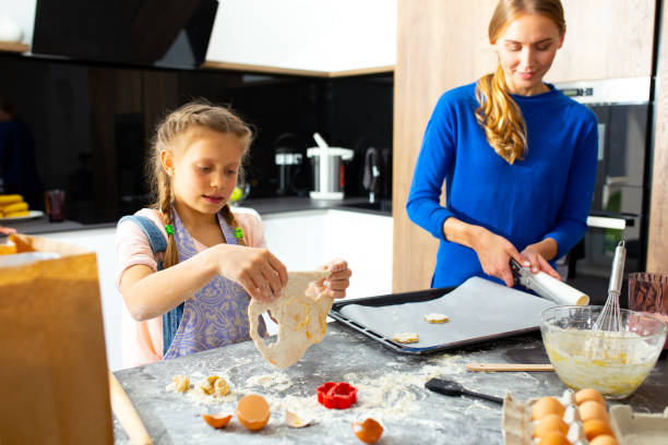 istock Loving mother and daughter making cookies in kitchen 1251174575