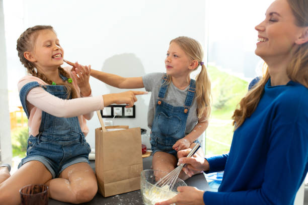 istock Cheerful young woman making cookies with cute daughters 1251174637
