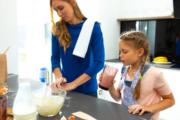 istock Cute daughter watching how mother making cookies 1251174653