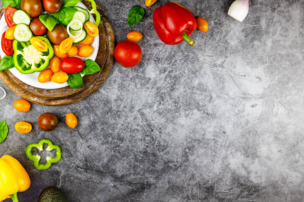 istock Fresh organic ingredients for salad making: avocado, tomatoes, basil on rustic background, top view. Flat lay with place for text. Vegan and healthy food concept 1251177153
