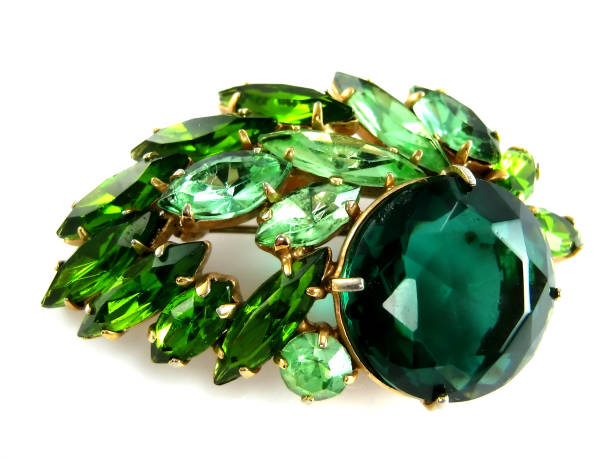 istock Emerald brooch with shiny gemstones isolated over white 1251178290