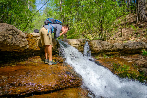istock Hiker splashes himself with water from natural stream 1251178538