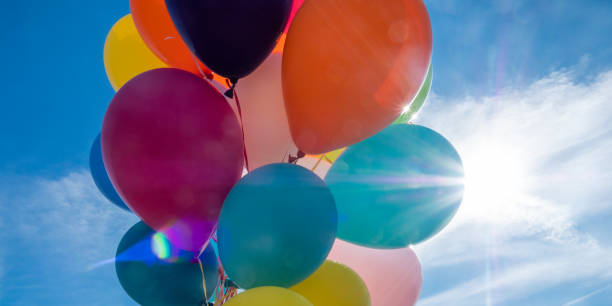 istock Colorful balloons with cloudy sky and sun in background 1251178573