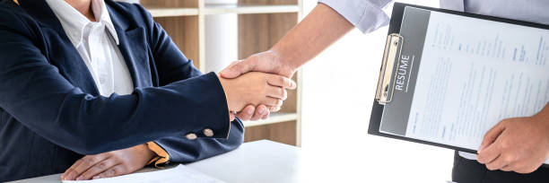 greeting new colleagues, handshake while job interviewing, female candidate shaking hands with interviewer or employer after a job interview, employment and recruitment concept - thinking professional occupation unemployment job search imagens e fotografias de stock