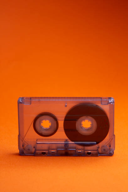istock Transparent audio cassette tape orange background. Front, view. 1251183967