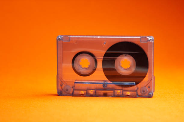 istock Transparent audio cassette tape orange background. Front, view. 1251185071