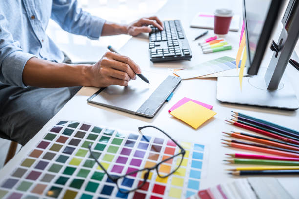istock Image of male creative graphic designer working on color selection and drawing on graphics tablet at workplace with work tools and accessories in workspace 1251185653