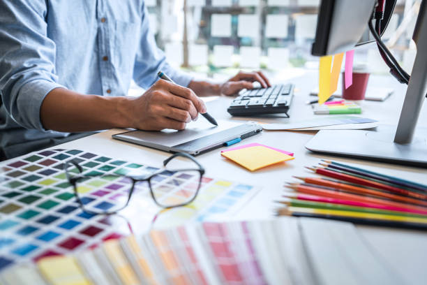 istock Image of male creative graphic designer working on color selection and drawing on graphics tablet at workplace with work tools and accessories in workspace 1251185657