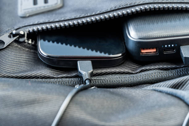 istock Smartphone charging with black energy bank in backpack 1251188550