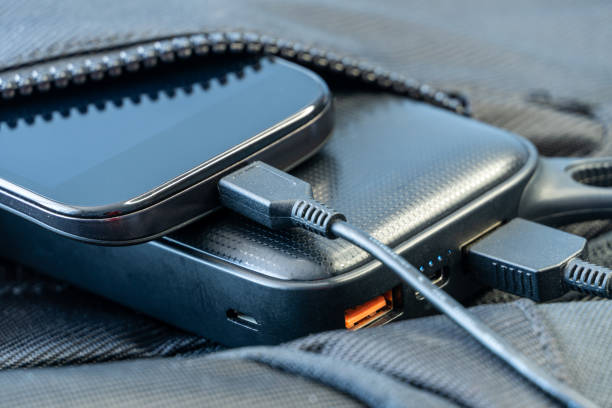 istock Smartphone charging with black energy bank in backpack 1251188573
