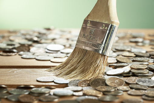 Horizontal shot of money sweeps away with a brush close-up on a green background. The background in blurr.