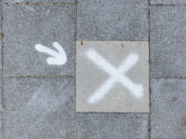 istock sidewalk wit ha white painted cross and white arrow 1251189590