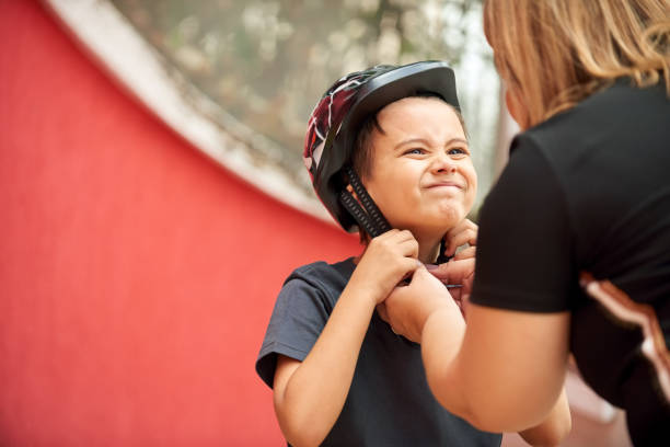 This is too tight mom Shot of a mother helping son wearing helmet for cycling kids Motorbike Helmets stock pictures, royalty-free photos & images