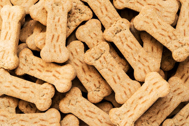 Pile of Bone shaped dog biscuits of brown color. Abstract wallpaper. Pile of Bone shaped dog biscuits of brown color. Abstract wallpaper. dog biscuit photos stock pictures, royalty-free photos & images