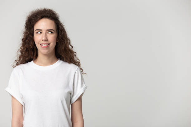 istock Smiling young girl look at blank copy space aside 1251191001