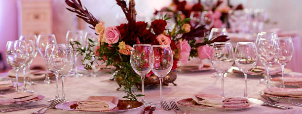 istock A dining table filled with wine glasses served for guests. Table with flowers in the middle. 1251192089