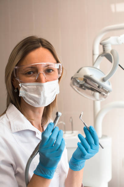 istock Female dentist doctor holding and showing a tooling. 1251193052