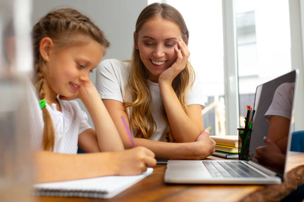 istock Happy mother helping daughter to study at home 1251193704