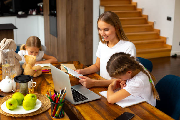 istock Happy mother helping kids to study at home 1251193766