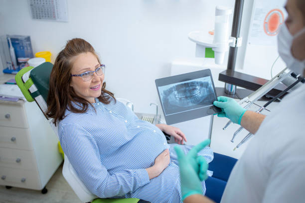 임신 한 여성에게 엑스레이 스캔을 보여주는 치과 의사 - dentist office dentists chair dental equipment medical equipment 뉴스 사진 이미지