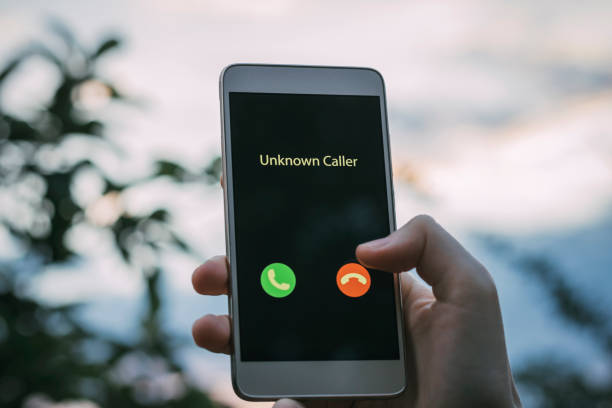 Unknown caller. A girl holds a phone in his hand and thinks to end the call. Incoming from an unknown number. Incognito or anonymous stock photo