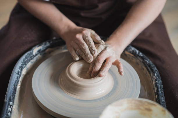 istock Close up of unrecognizable ceramist forming handcrafted clay vase using special tool and potter circle 1251195147