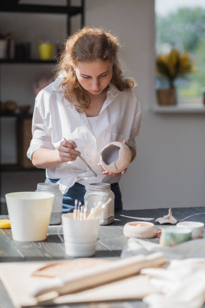 istock Production process of pottery. Application of glaze brush on ceramic ware 1251195229