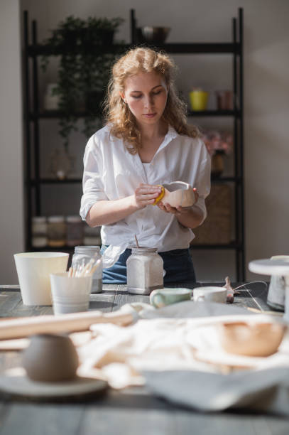 istock Production process of pottery. Application of glaze brush on ceramic ware 1251195231