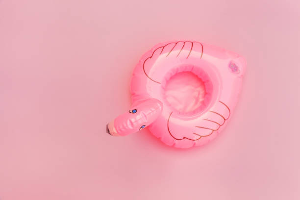 istock Summer beach composition. Simply minimal design with Inflatable flamingo isolated on pastel pink background. Pool float party, trendy celebrity fashion concept. Flat lay top view copy space 1251196241
