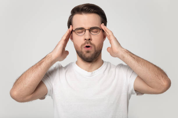 istock Unwell man in glasses massage temples suffering from headache 1251198897