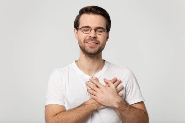 istock Grateful man in glasses feel thankful keeping hands on chest 1251198899