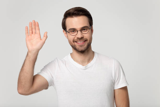 istock Smiling man in glasses wave hand say hello to audience 1251198901