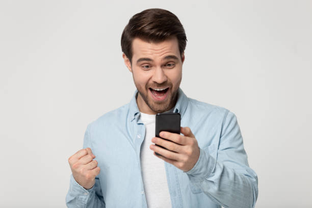 istock Overjoyed young man feel excited receiving good message on cell 1251198953
