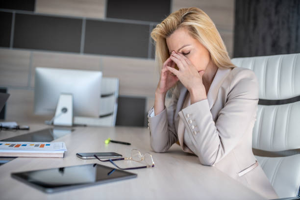istock A business woman is sitting in an office at a desk thinking about problems 1251200912