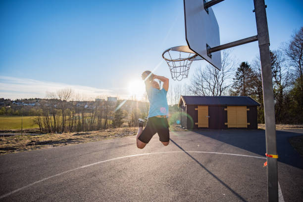 istock Young basketball street player making slam dunk. 1251201365