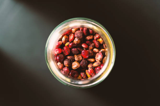 Sumac fruits in glass jar Sumac fruits in glass jar on black background. Spices from directly above, selective focus. cherry colored stock pictures, royalty-free photos & images