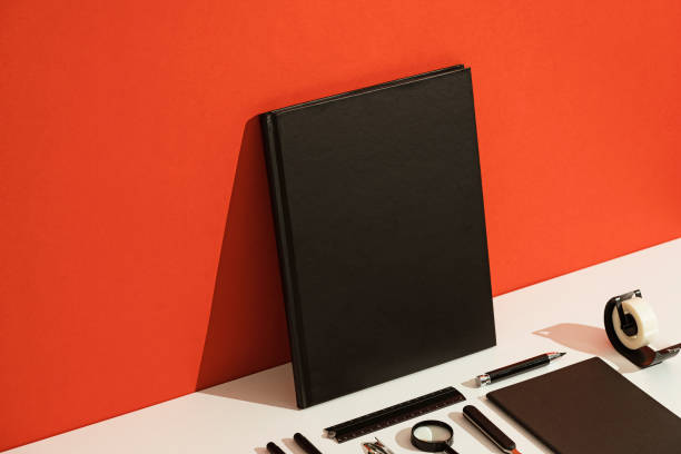 Top view of black photorealistic notebook on black background.