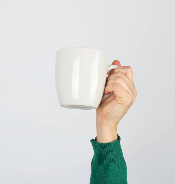 istock white ceramic cup in a female hand on a white background 1251208068