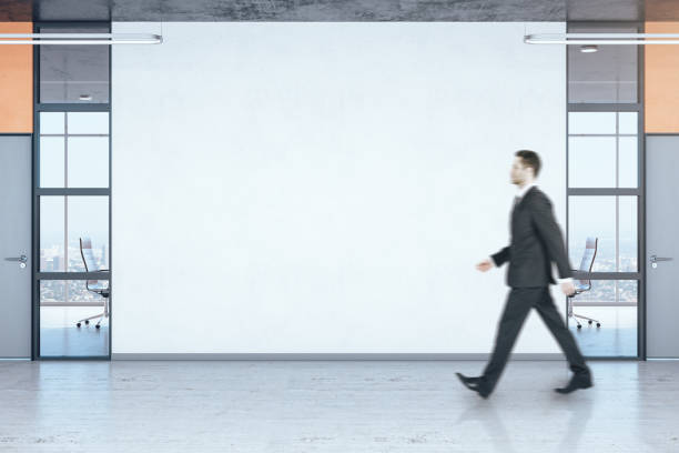 istock Businessman walking in office hall 1251208701