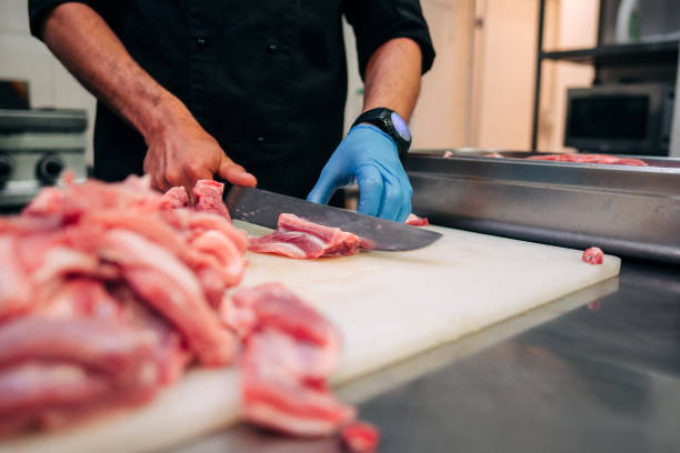 istock Male chef cutting raw pork ribs in restaurant kitchen 1251219189