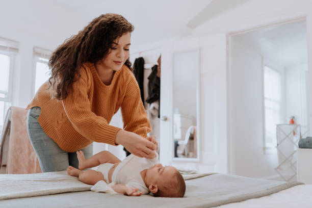 istock Mixed race latin mother changing her baby diaper 1251223021