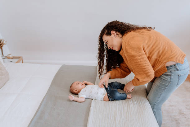 istock Mixed race latin mother changing her baby diaper 1251223056