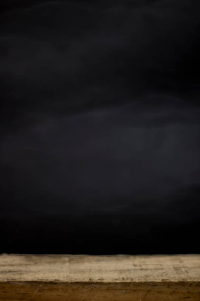 Empty wooden desk with rough black background texture to display products