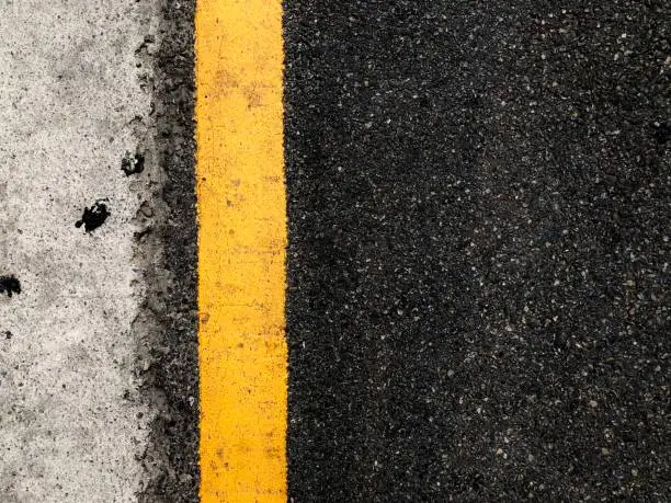 Photo of a yellow line on the black asphalt road
