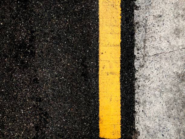 istock a yellow line on the black asphalt road 1251227770