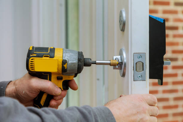 istock Handyman using a drill to installing lock in door in a house 1251228589
