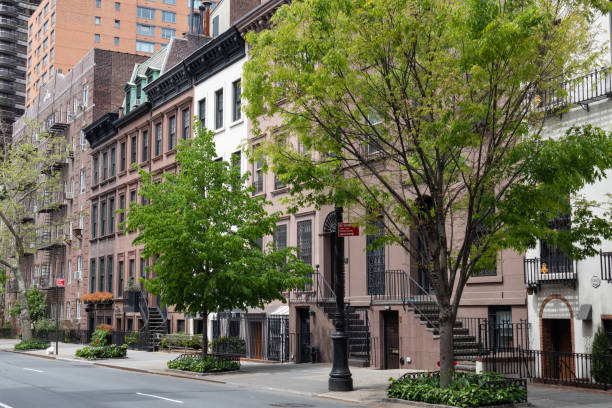 Row of Beautiful Old and Fancy Townhouses along an Empty Street on the Upper East Side of New York City A row of beautiful old and fancy townhouses with green trees along an empty street and sidewalk on the Upper East Side of New York City upper east side manhattan stock pictures, royalty-free photos & images