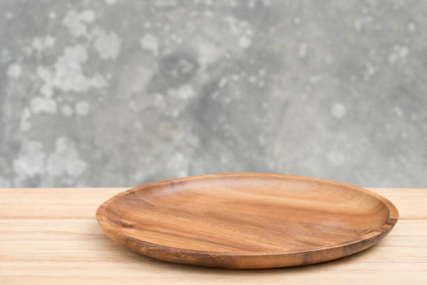 istock Empty wooden tray on perspective wooden table over blur old gray cement wall background. Can be used mock up for montage products display or design layout. 1251232103