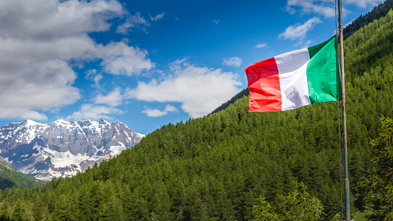 Italian flag in Gran Paradiso alpine landscape at springtime – northern Italy