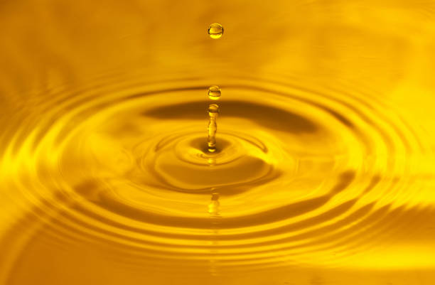 istock Yellow background, texture. Drops falling in water and circles walking on water, with reflection 1251240290